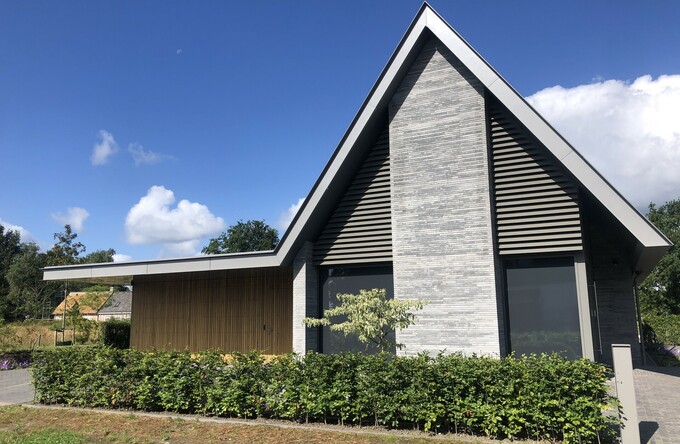Trapezia in kwartsgrijs harmoniëren met gevelsteen van residentie in Gilze en Rijen