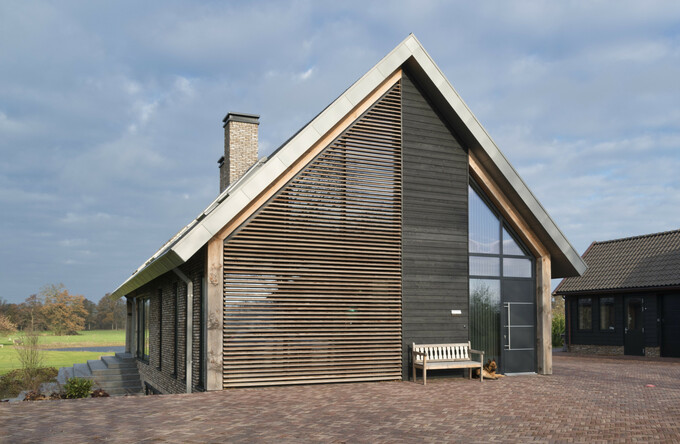 Schuurwoning voorzien van lamellen zonwering van Western Red Cedar