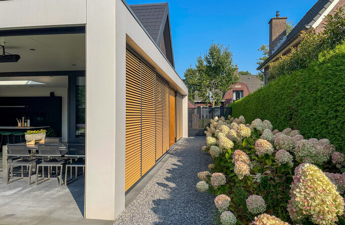 Aluminium lamellen van schuifpanelen en louvers van de risaliet uitgevoerd in dezelfde houtlook
